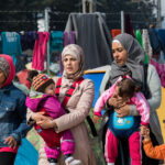 Two Women and four Children walking